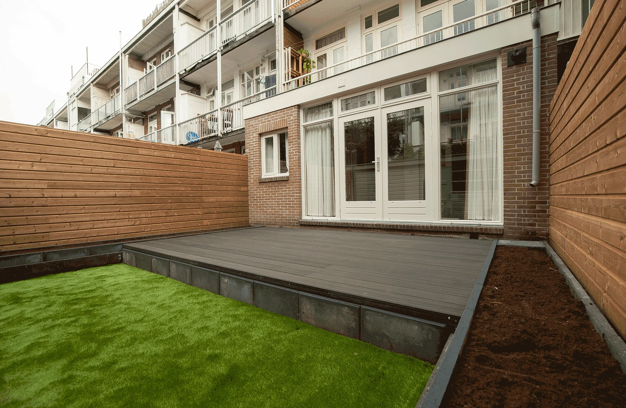 Amsterdam city garden with composite terrace and wooden fences