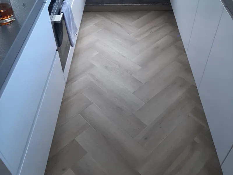 Grijze visgraatvloer in een keuken