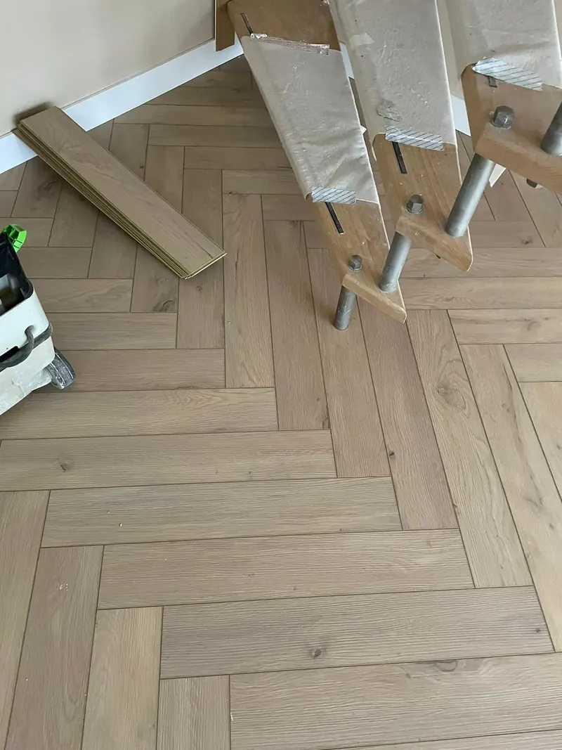 Visgraatvloer tijdens het leggen, met de trap afgeplakt